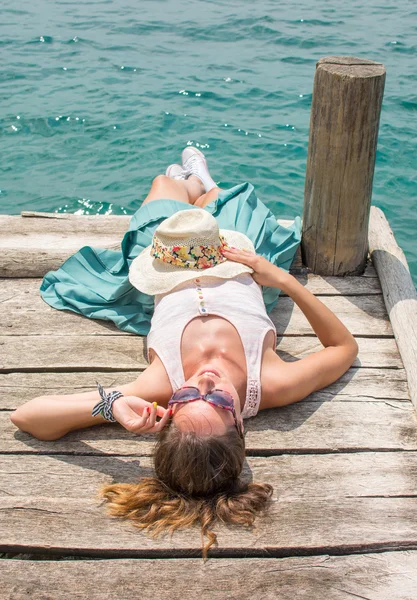 Jeune femme allongée sur un quai — Photo