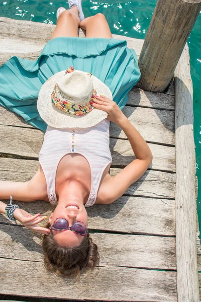 Young woman lying on a dock — Stock Photo, Image