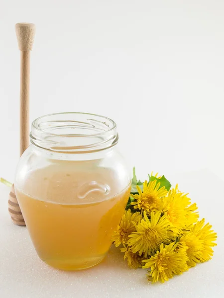 Pot met honing en gele paardebloem bloem — Stockfoto