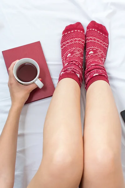 Mujer con una taza de té en la cama —  Fotos de Stock