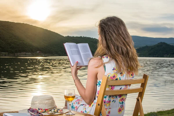 Woman reading a book by the lake — Stock Photo, Image