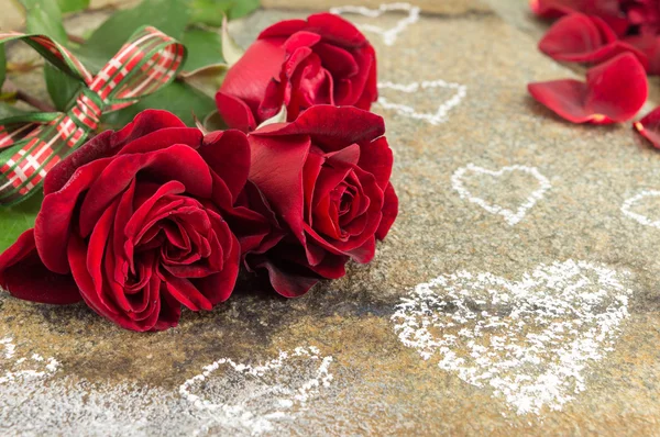 Ramo de rosas rojas con cinta en la mesa de piedra — Foto de Stock