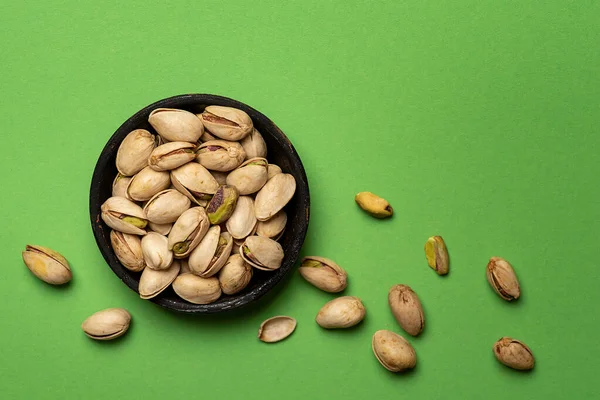 Nueces Pistacho Tostadas Saladas Tazón Sobre Fondo Verde Vista Superior — Foto de Stock