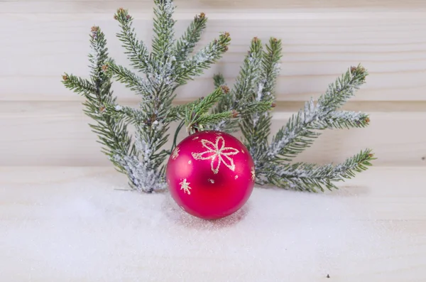 Красное рождественское украшение и елка, покрытая снегом — стоковое фото