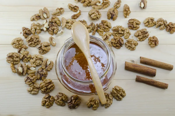 Jar of honey, wooden spoon and wallnuts — Stock Photo, Image