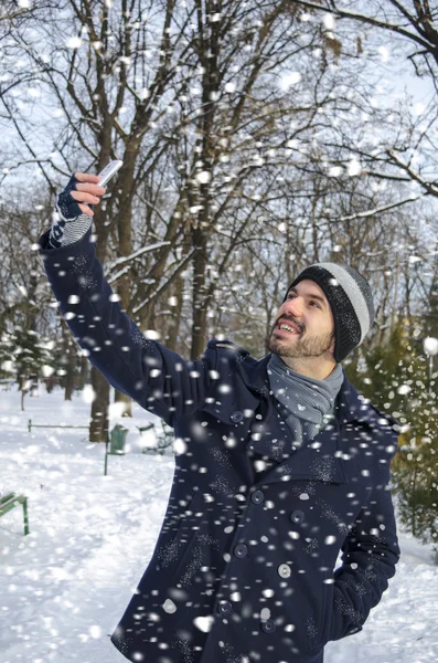 Hombre hablando un selfie mientras está nevando — Foto de Stock