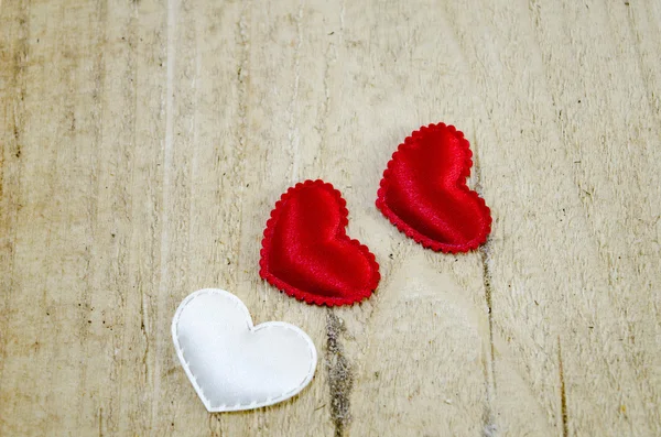 Drie harten op een houten bord — Stockfoto