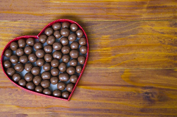 Krabice ve tvaru srdce naplněné malé čokolády koule — Stock fotografie