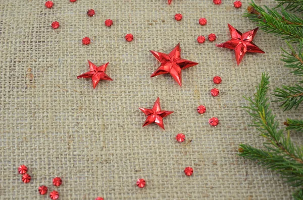 Red Christmas stars and a fir tree branch — Stock Photo, Image