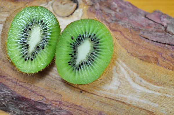 Setengah kiwi di atas meja kayu — Stok Foto