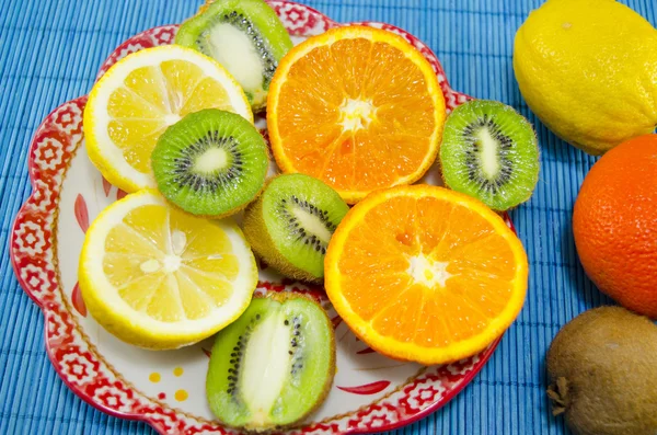 Πολύχρωμα φρούτα επιδόρπιο σε ένα πιάτο — Φωτογραφία Αρχείου
