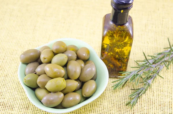 Olive verdi e una bottiglia di olio vergine di oliva — Foto Stock