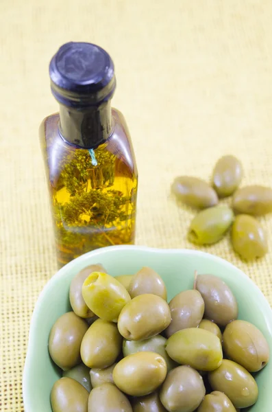 Зелені оливки і пляшка незайманої оливкової олії — стокове фото