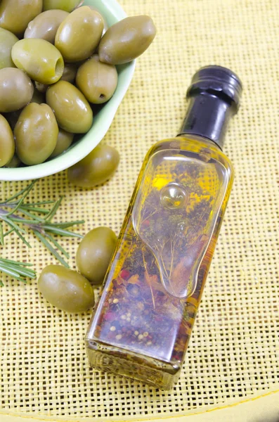 Olive verdi e una bottiglia di olio vergine di oliva — Foto Stock
