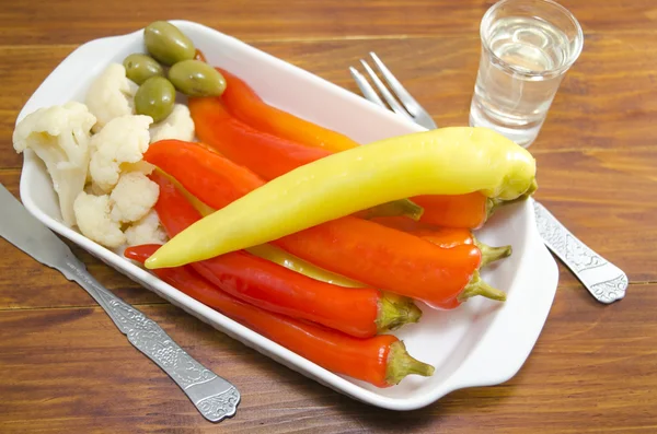 Pimientos en escabeche, coliflor y aceitunas en un plato —  Fotos de Stock