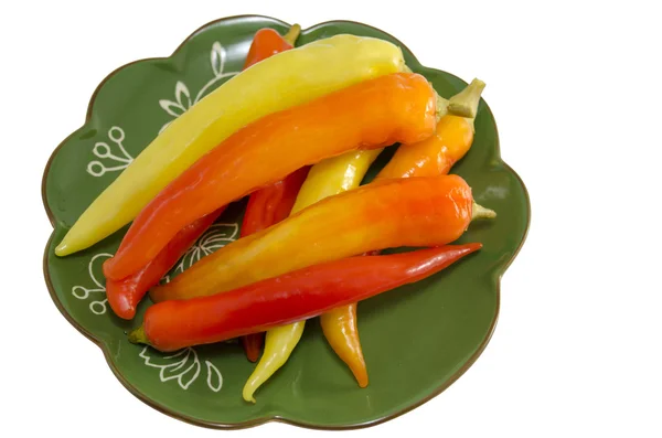 Pickled peppers on a green plate isolated — Stock Photo, Image