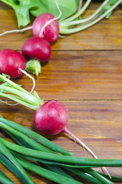 Rajutan dan bawang muda di atas meja kayu — Stok Foto