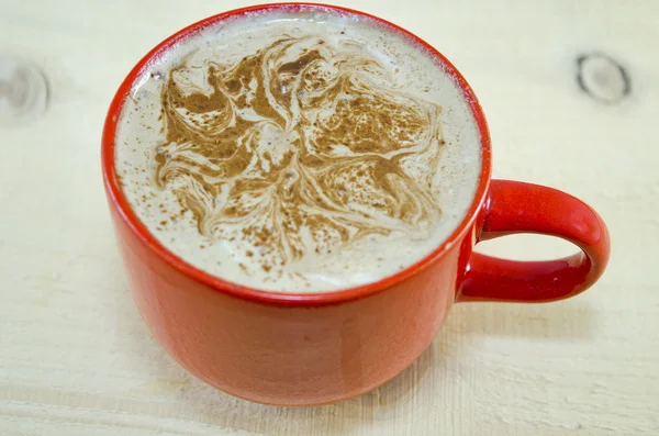 Tazza rossa di caffè con schiuma decorata — Foto Stock