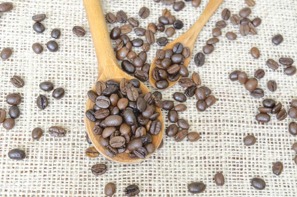 Cucharas grandes y pequeñas llenas de granos de café — Foto de Stock