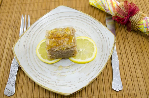 Juicy baklava on a plate decorated with lemon slices — Stock Photo, Image