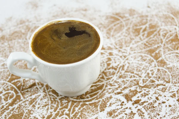 Tasse Kaffee auf einem mit Kaffeekörnern bedeckten Tisch — Stockfoto