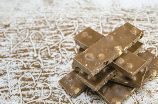 Chocolate al por mayor sobre una mesa rociada con cacao —  Fotos de Stock