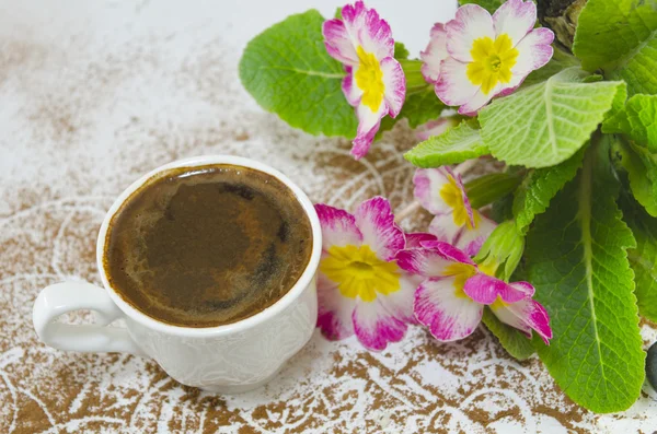 Tasse Kaffee auf einem Tisch mit Blumen dekoriert — Stockfoto