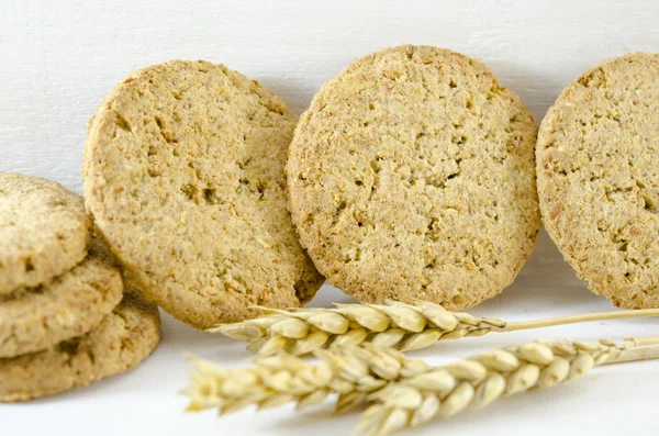 Интегральные печенье и пшеница на белом фоне — стоковое фото