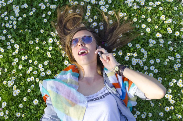 Morena menina falando no telefone na grama — Fotografia de Stock