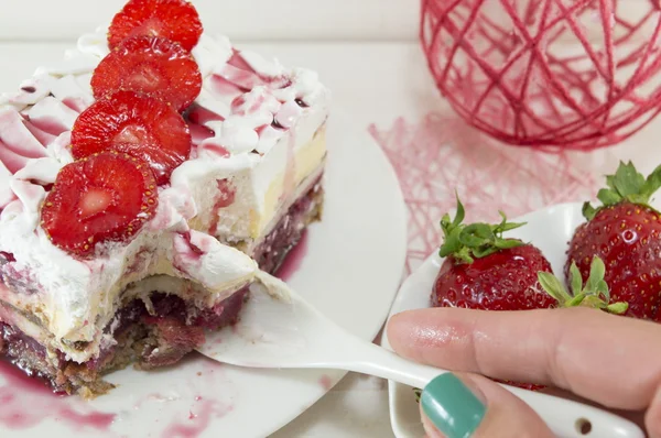 Girl eating strawberry cake with whipped cream — Stok fotoğraf