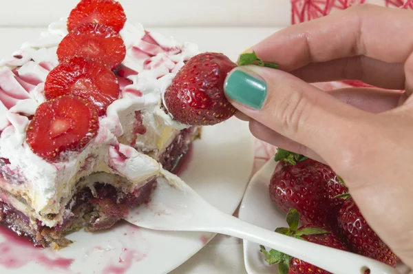 Girl dipping strawberry into whipped cream — Stok fotoğraf