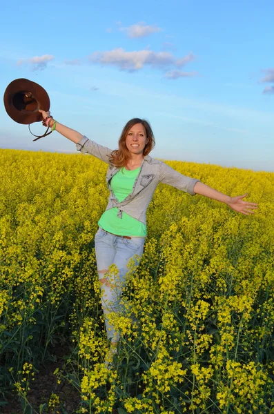 Chica posando en un campo de flores amarillas —  Fotos de Stock