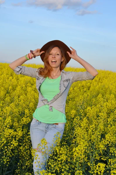 Menina posando em um campo de flores amarelas — Fotografia de Stock