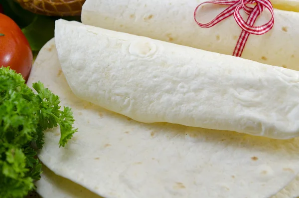 Τυλιγμένο άδειο tortillas σε ένα τραπέζι με ντομάτα, μαρούλι και ζαμπόν — Φωτογραφία Αρχείου