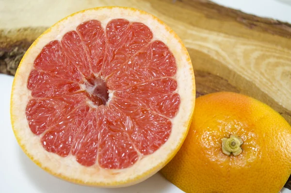 Grapefruit in Scheiben geschnitten auf einem Holzbrett — Stockfoto