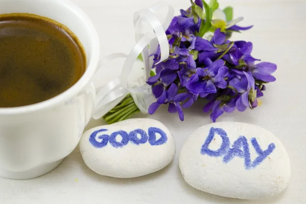 Weiße Tasse Kaffee auf einem Tisch mit Blumen dekoriert — Stockfoto