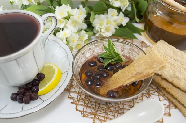 Чай с черникой на украшенном цветами столе — стоковое фото