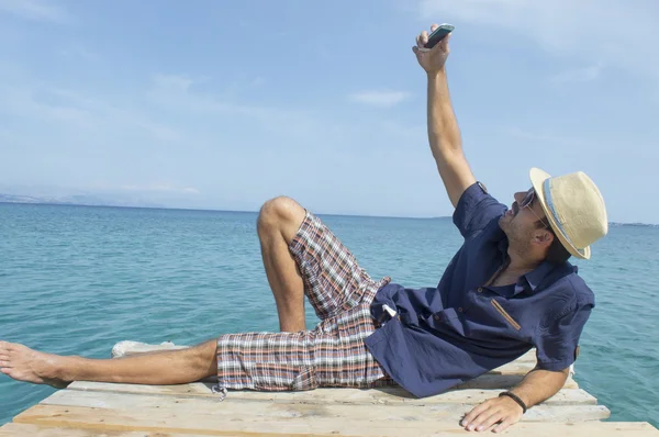 Muž s selfie s jeho chytrý telefon na pláži — Stock fotografie