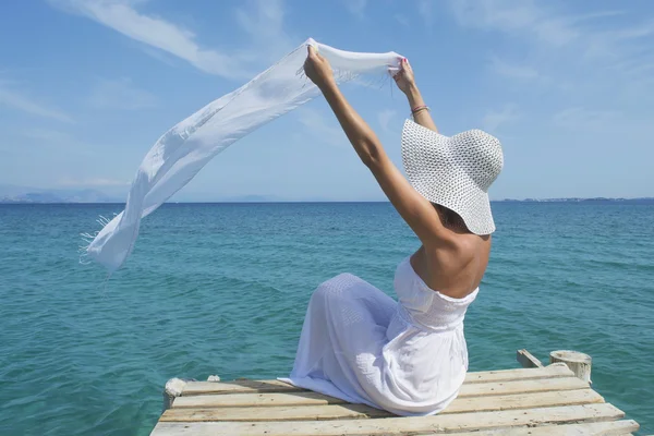 Mulher acenando um lenço branco em uma doca do mar — Fotografia de Stock