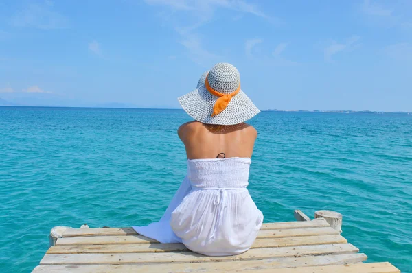 Young woman looking at the sea from a dock — Stock Photo, Image