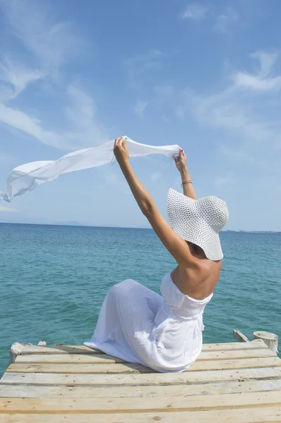 Woman waving a white scarf on a sea dock — Stock Photo, Image