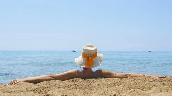 Girl looking at sea while sitting on the beach — ストック写真