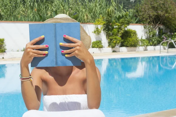 Havuzun yanında bir kitap okuma kız — Stok fotoğraf