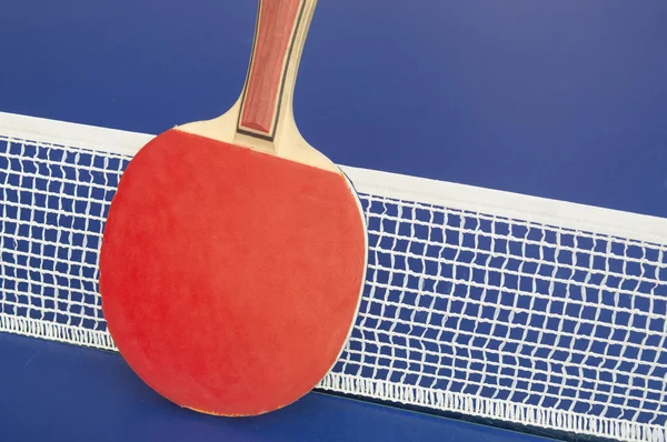 Table tennis paddle and net on ac blue table-tennis table — 스톡 사진