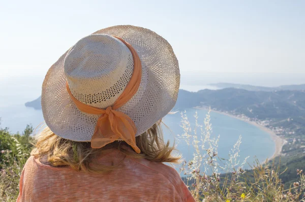 Giovane ragazza con cappello di paglia guardando il mare da extraordin — Foto Stock