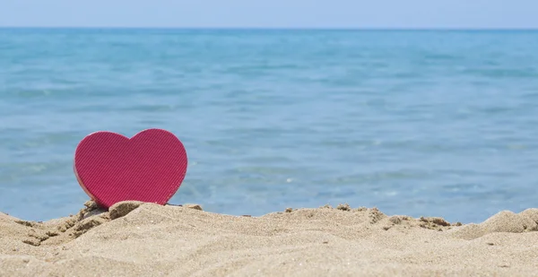 Forma de coração mergulhado na praia de areia com o olhar no horizonte — Fotografia de Stock