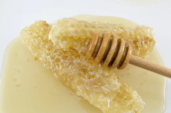 Honeycomb covered with honey and dipper spoon on white — Stock Photo, Image