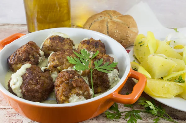 Homemade meatballs served in an orange bowl with corn bread, pot — Stock Photo, Image