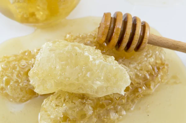 Honeycomb covered with honey and dipper spoon on white — Stock Photo, Image