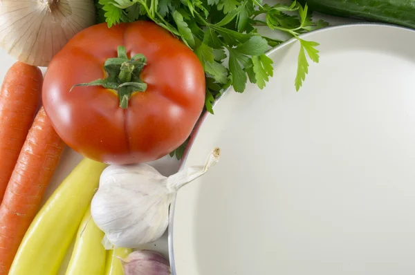 Цветные овощи на столе и большая белая тарелка для приготовления — стоковое фото
